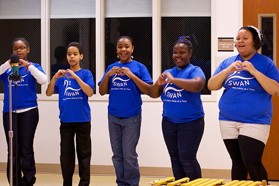 kids singing with heart sign over their chests